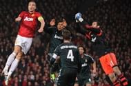 United's Nemanja Vidic (L) jumps for the ball with Real's Raphael Varane (C) at Old Trafford on March 5, 2013